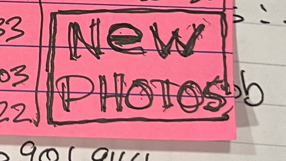 close up of the words "new photos" written in pen